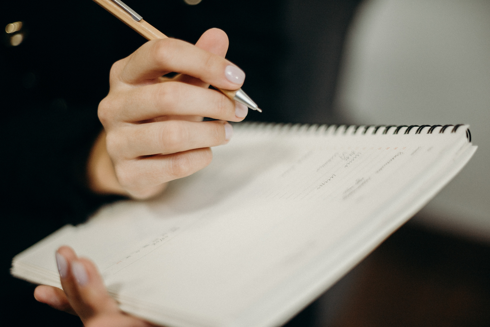 Person Writing on Notebook